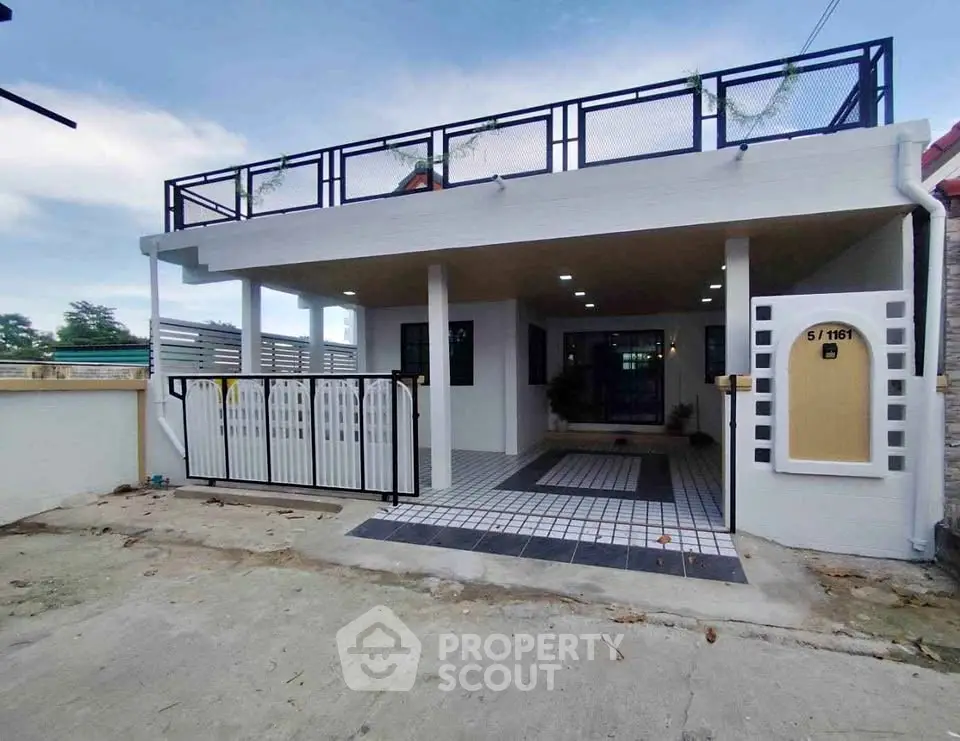 Modern single-story house with gated entrance and rooftop terrace