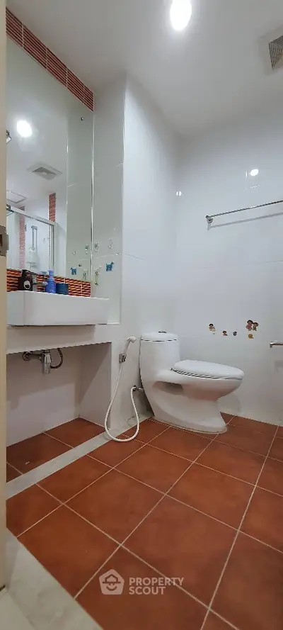 Modern bathroom with white fixtures and terracotta floor tiles