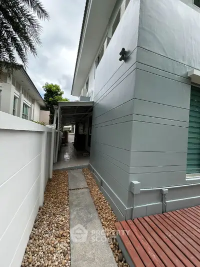 Modern exterior side pathway with sleek design and pebble landscaping