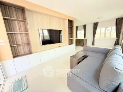 Spacious modern living room with sleek TV setup and ample natural light.