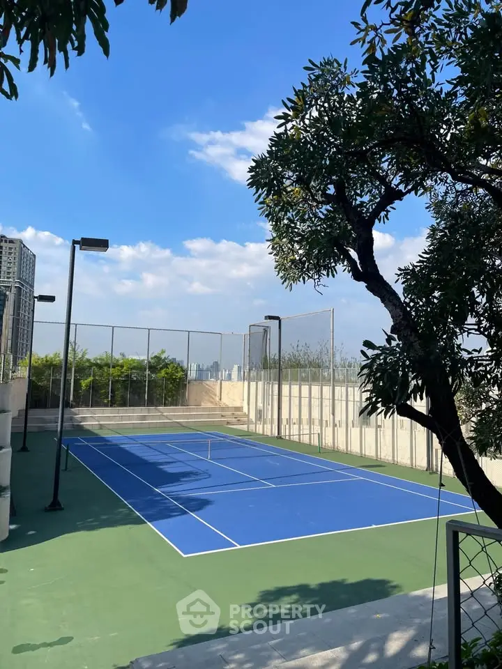 Stunning rooftop tennis court with city skyline views, perfect for urban living enthusiasts.