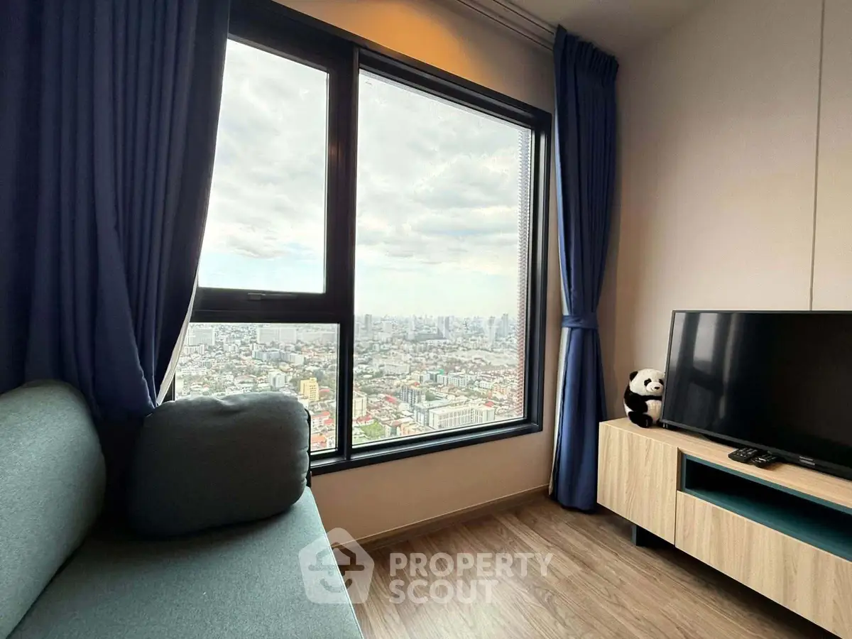 Modern living room with panoramic city view, cozy sofa, and stylish TV stand.