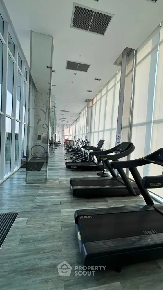 Modern gym with state-of-the-art equipment and floor-to-ceiling windows