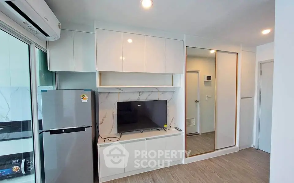Modern living room with sleek cabinetry and mirrored closet doors
