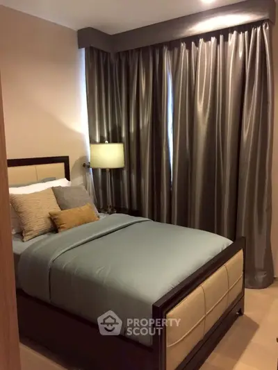 Cozy bedroom with elegant curtains and stylish bedding in modern apartment.