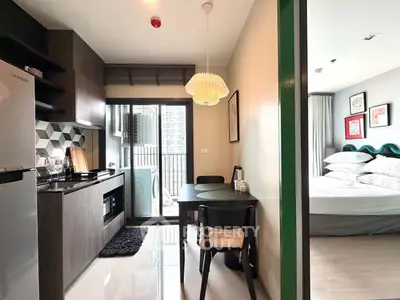 Modern apartment with sleek kitchen and cozy bedroom, featuring stylish decor and natural light.