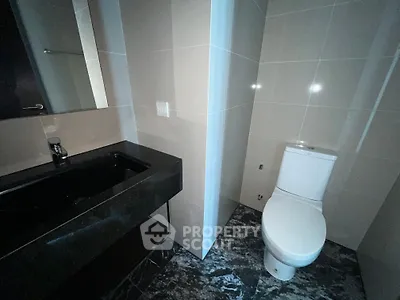 Modern bathroom with sleek black sink and tiled walls