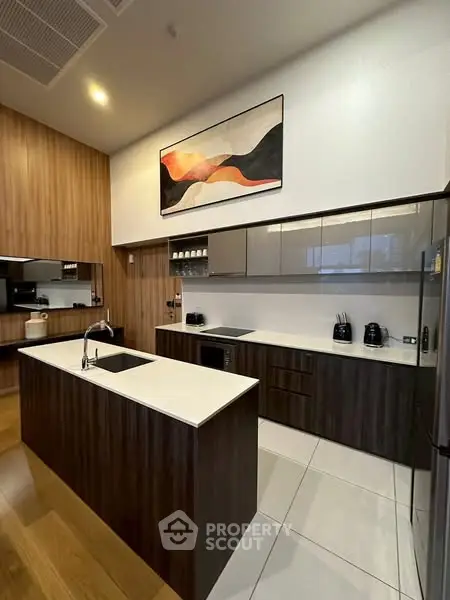 Modern kitchen with sleek design, featuring dark wood cabinets and a central island.