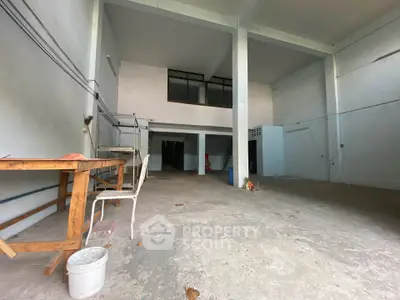 Spacious industrial-style open space with high ceilings and mezzanine level, ideal for creative projects or storage.