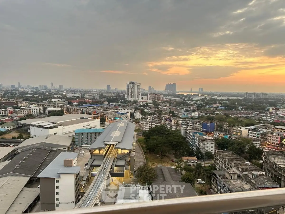 Stunning cityscape view from high-rise balcony at sunset, showcasing urban skyline and vibrant horizon.