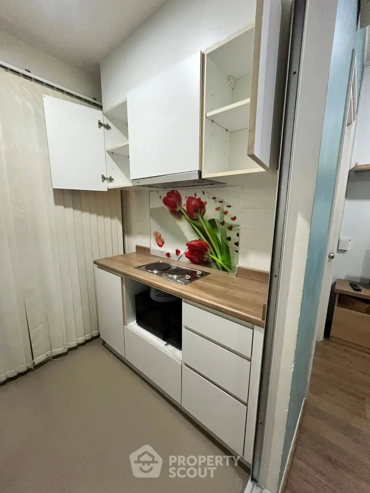 Modern compact kitchen with floral backsplash and sleek white cabinets