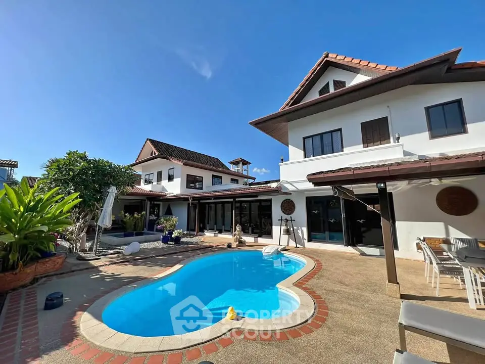 Luxurious villa with private pool and spacious outdoor area under clear blue sky.