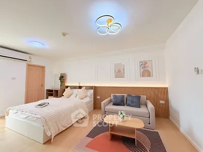 Spacious modern bedroom with cozy seating area and stylish decor