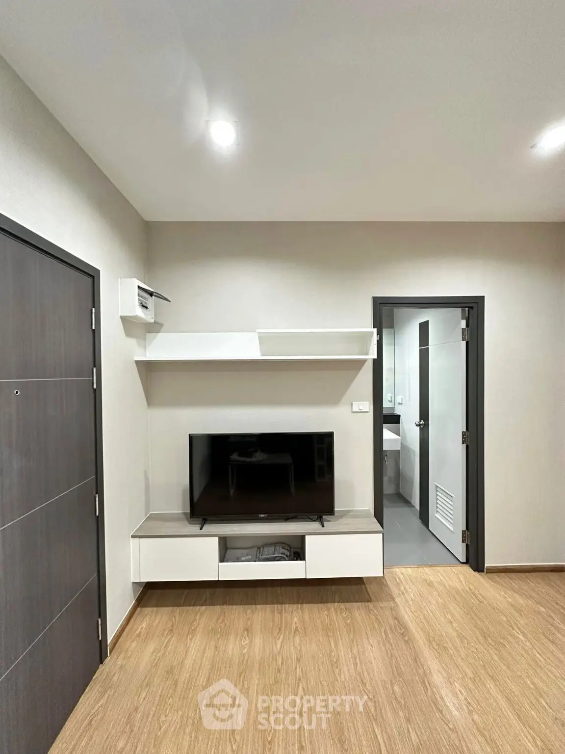 Modern living room with sleek TV setup and wooden flooring