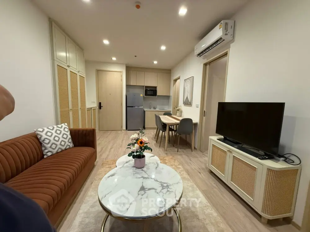 Modern living room with stylish furniture and open kitchen layout in a cozy apartment.