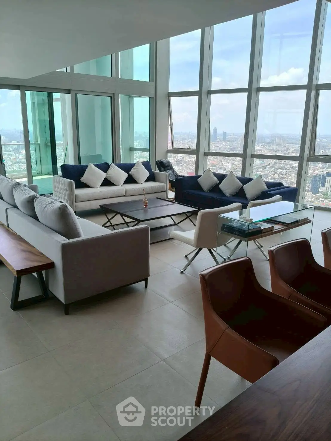 Luxurious high-rise living room with panoramic city views and modern furnishings.
