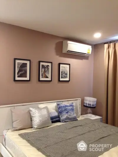 Cozy bedroom with modern decor and air conditioning, perfect for relaxation.