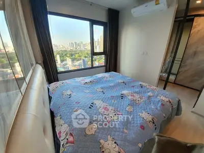Cozy bedroom with city view, featuring a large window and modern decor.
