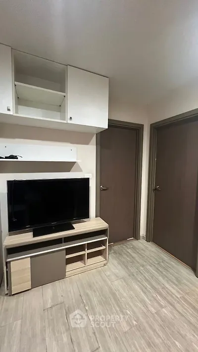Modern living room with sleek TV stand and storage cabinets, featuring minimalist design and neutral tones.