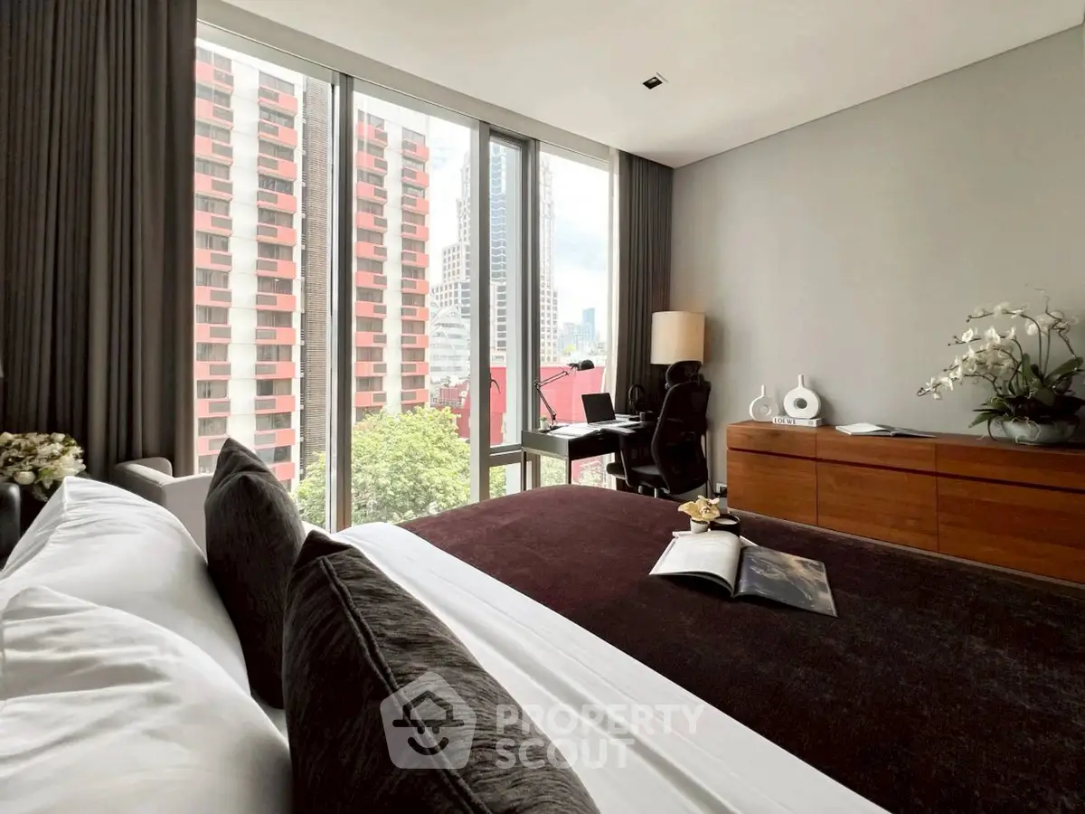 Luxurious bedroom with city view, modern decor, and elegant furnishings.