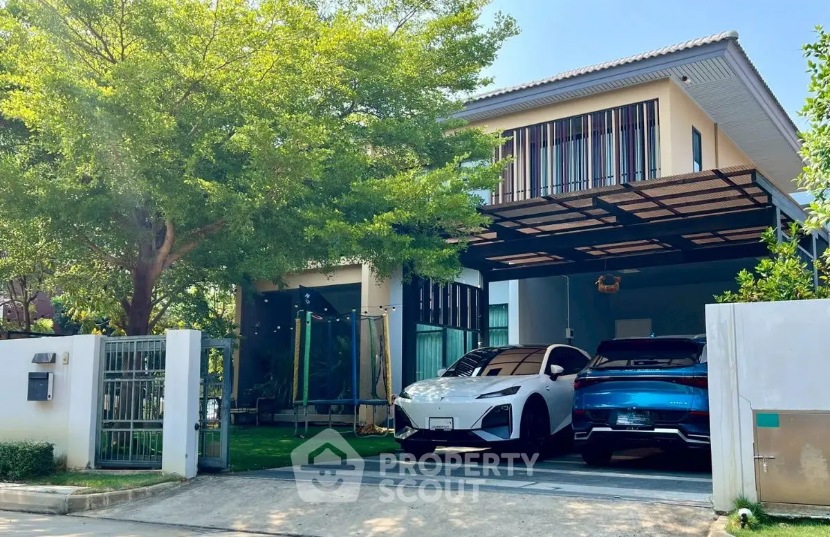 Modern two-story house with spacious driveway and luxury cars parked under a stylish carport.