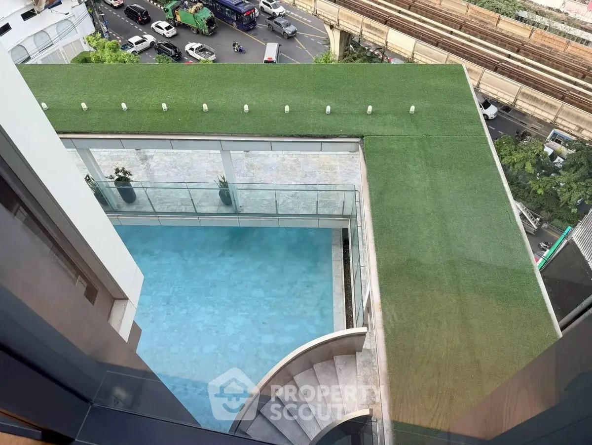 Stunning rooftop pool with city view and lush green terrace
