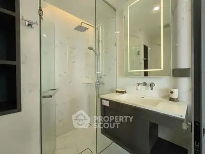 Modern bathroom with glass shower and illuminated mirror
