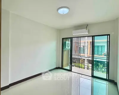 Spacious living room with large windows and balcony access in modern apartment.