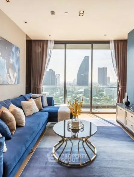 Luxurious living room with stunning city view, elegant blue sofa, and modern decor in high-rise apartment.