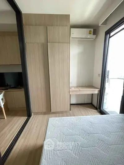 Modern bedroom with wooden wardrobe and air conditioning in a stylish apartment.