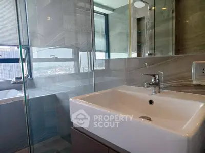 Modern bathroom with sleek sink and glass shower in high-rise apartment