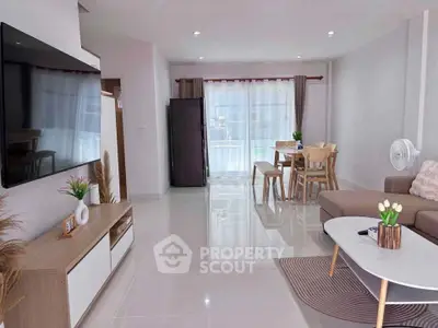 Modern living room with sleek furniture and large TV, perfect for relaxation and entertainment.