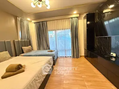 Spacious modern bedroom with elegant decor and large windows.