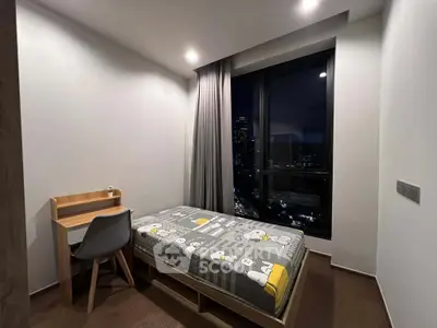 Cozy bedroom with city view, featuring a single bed and study desk, perfect for urban living.