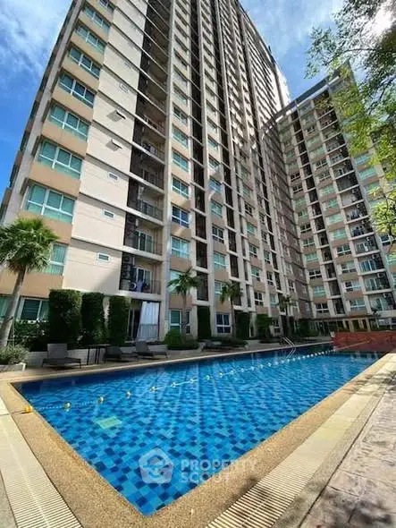 Modern condominium with a spacious outdoor pool and lush greenery, perfect for urban living.