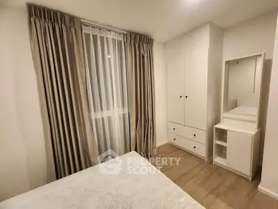 Cozy bedroom with elegant curtains and built-in wardrobe in modern apartment.
