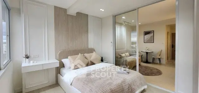 Modern bedroom with elegant decor and large mirror closet doors in a stylish apartment.