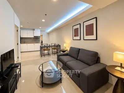 Modern living room with sleek furniture and open kitchen layout in a stylish apartment.