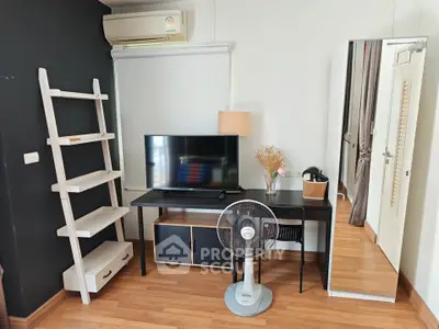 Modern living room with stylish furniture and TV setup, featuring a sleek black desk and ladder-style shelf.