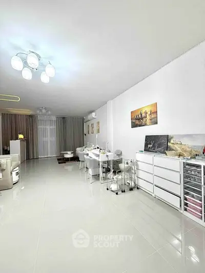 Spacious modern living room with sleek white furniture and elegant decor, perfect for relaxation and entertainment.