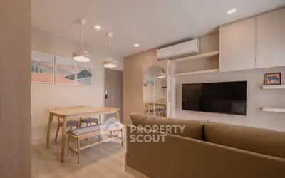 Modern living room with stylish decor and dining area in open layout apartment.