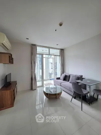Modern living room with sleek furniture and large windows offering natural light.