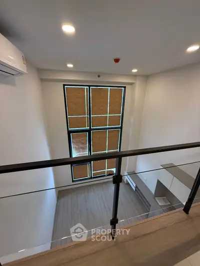 Modern loft with high ceilings and large windows, featuring sleek design and ample natural light.