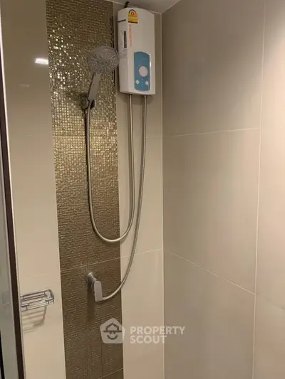 Modern bathroom with sleek shower and water heater, featuring elegant tile design.