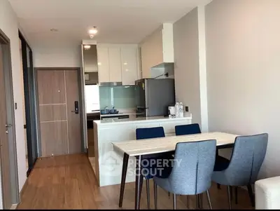 Modern kitchen with open layout flows seamlessly into a cozy dining area, featuring sleek cabinetry, gas stove, and ample natural light, perfect for entertaining.