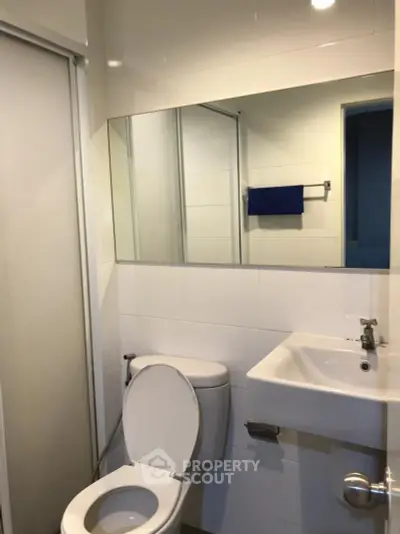 Modern bathroom with sleek white tiles and contemporary fixtures.