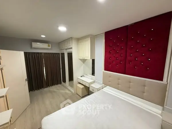 Modern bedroom with stylish red accent wall and sleek furnishings