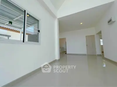 Spacious modern interior with high ceilings and large windows, perfect for natural light.