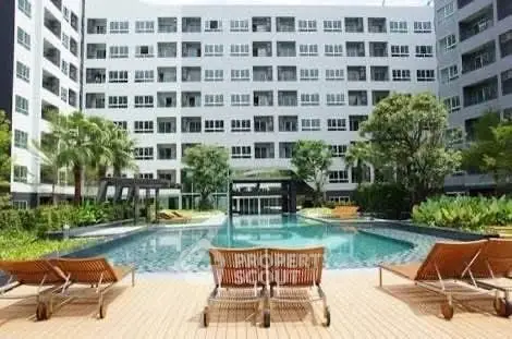 Luxurious apartment complex with stunning pool and lush greenery, perfect for relaxation and leisure.