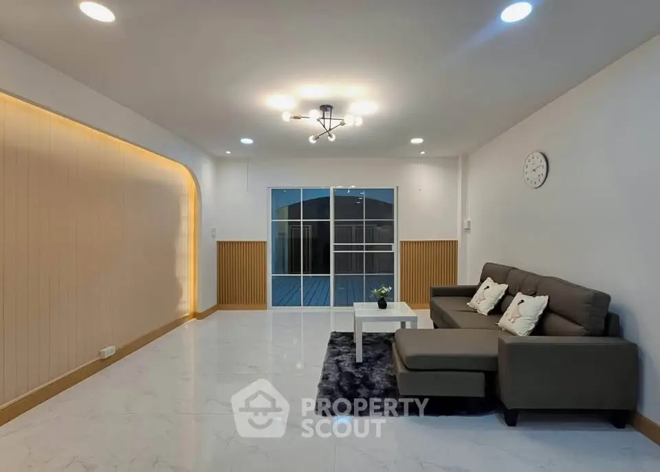 Spacious modern living room with elegant lighting and cozy seating area.